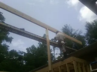 Carpenter setting a ridge beam over a new addition frame — Ice Dam Removal by Roofing Brothers in Stockbridge